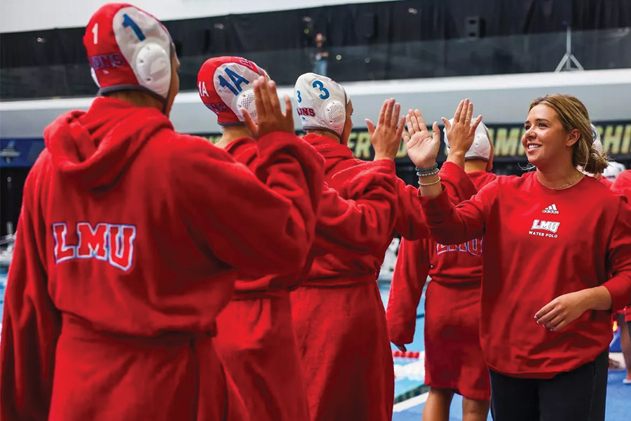 LMU Women's Water Polo Team High Fiving Associate Head Coach Sarah Kreiser
