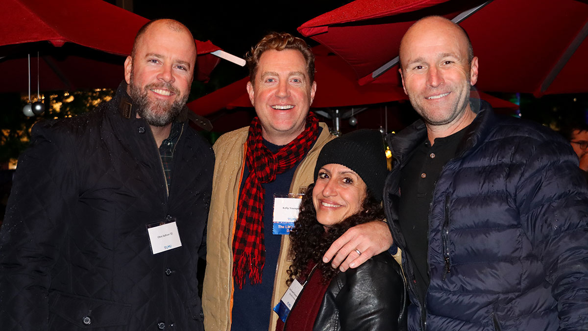 Four staff members wearing winter coats and smiling