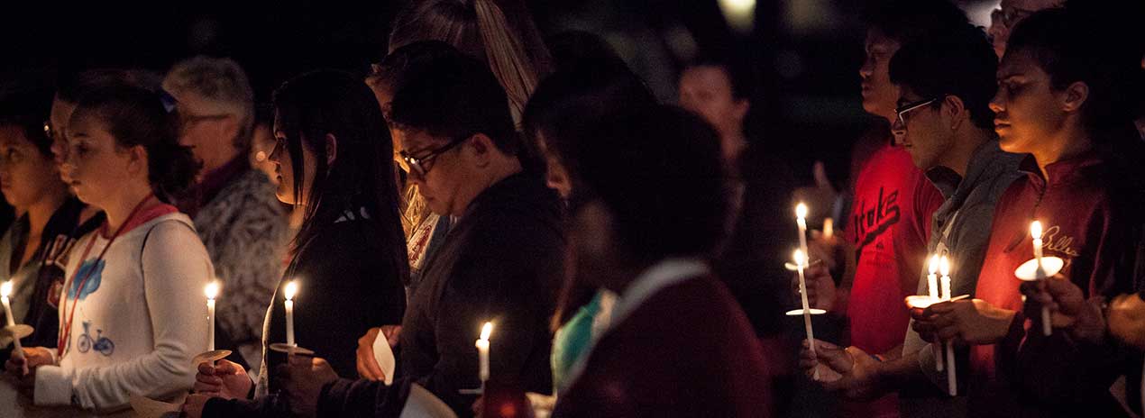 Group of people holding candles in a gathering